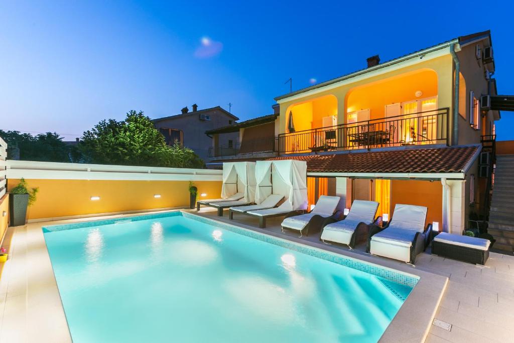 una piscina con sillas y una casa en House Andja with Pool, en Banjole