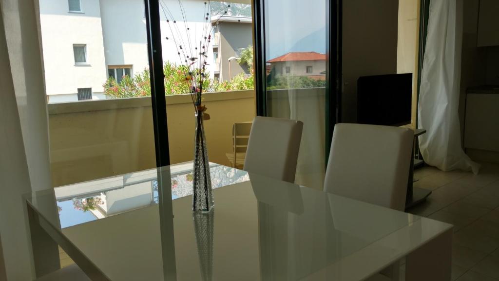 リーヴァ・デル・ガルダにあるBRIONE47のガラステーブル(白い椅子、花瓶付)