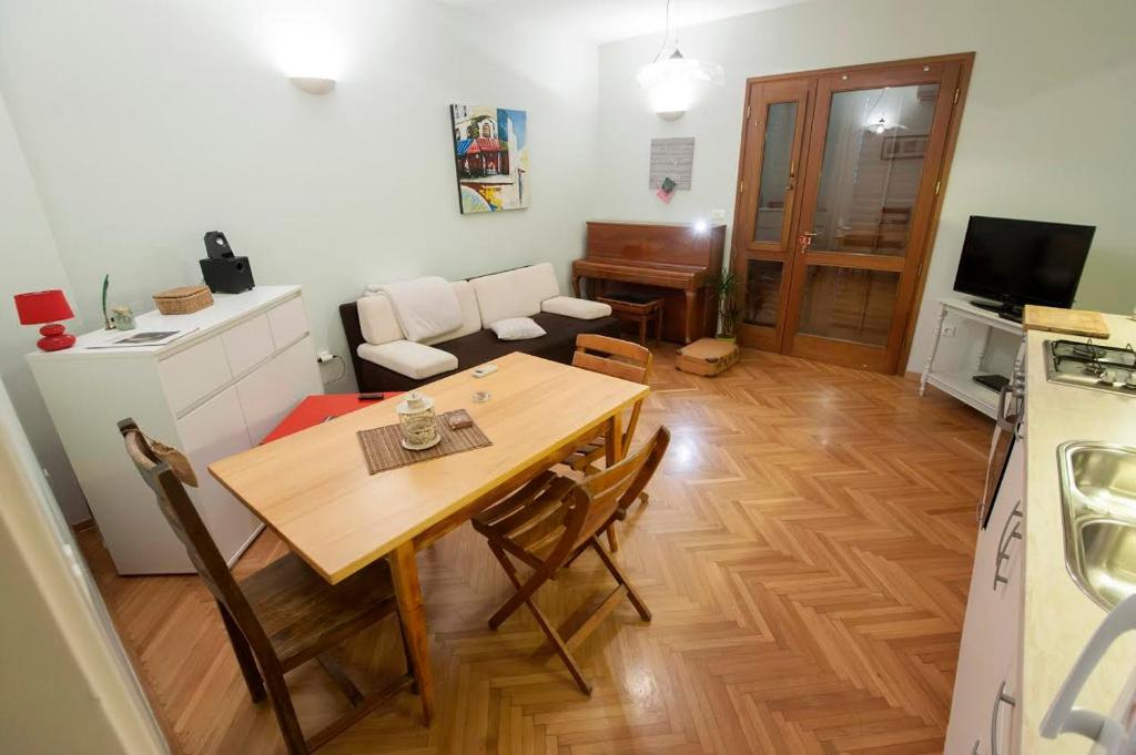 cocina y comedor con mesa de madera y sillas en Sunny apartment, en Zadar