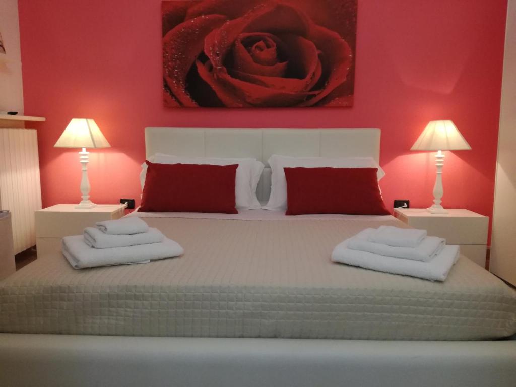 a bedroom with a bed with red walls and two lamps at Casa del Corso in Taviano
