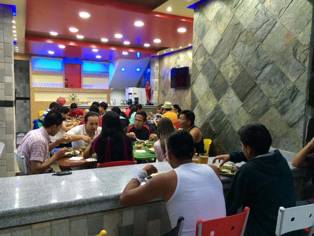 a group of people eating in a restaurant at Hotel Joya de la Selva in Tena