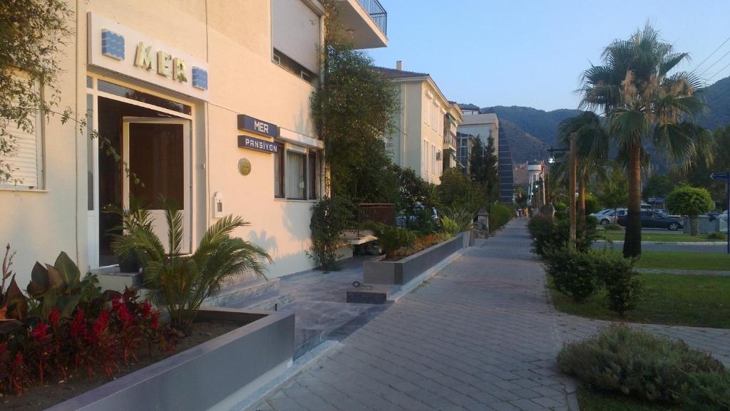 a sidewalk in front of a building with plants at Mer Pansiyon in Fethiye