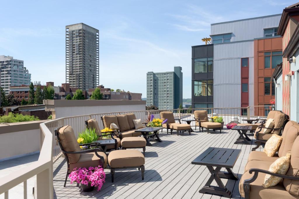 a rooftop patio with chairs and tables on a building at Belltown Inn in Seattle