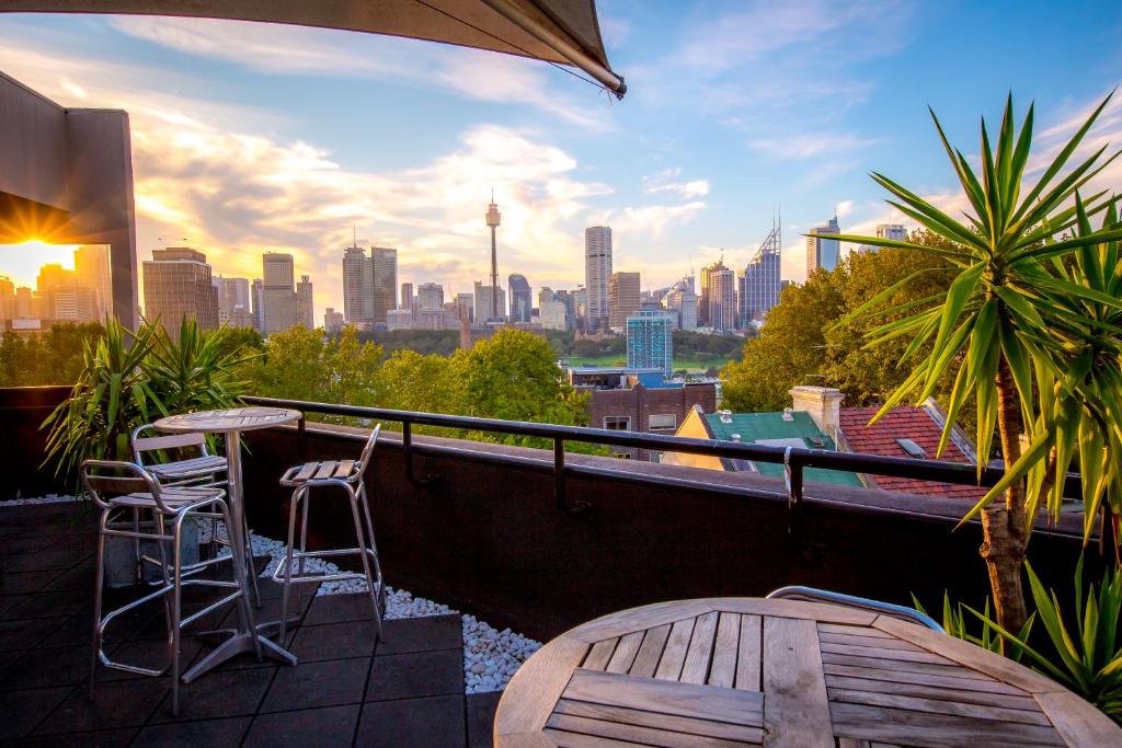 uma varanda com uma mesa e cadeiras e um horizonte da cidade em Sydney Potts Point Central Apartment Hotel Official em Sydney