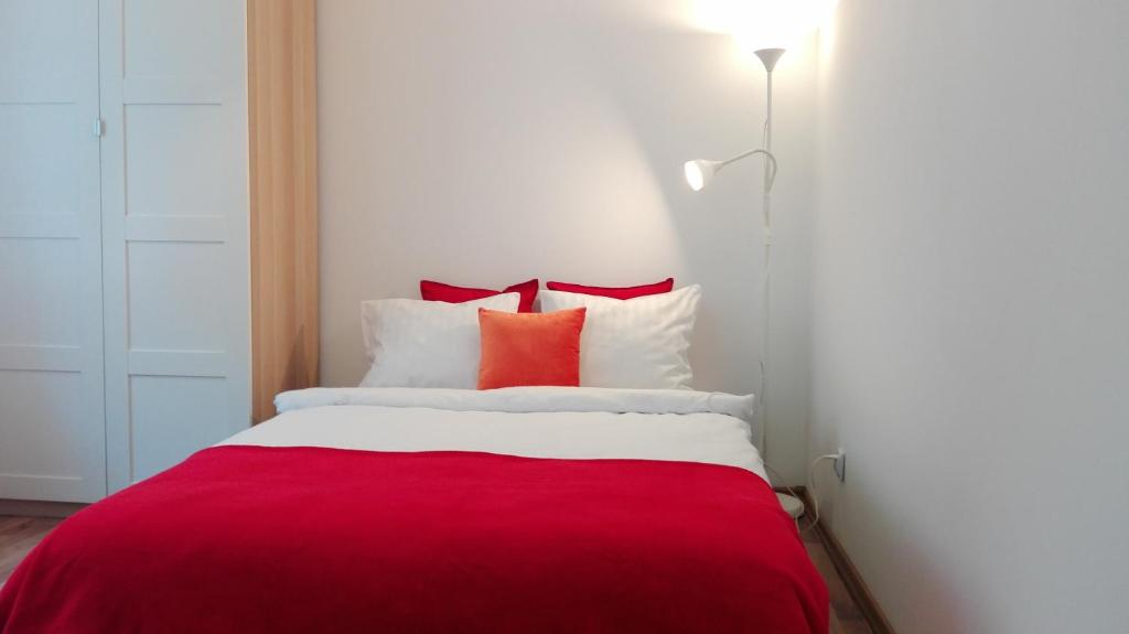 カトヴィツェにあるStudio Wiola Centrumのベッドルーム1室(赤と白のベッド1台、赤の枕付)