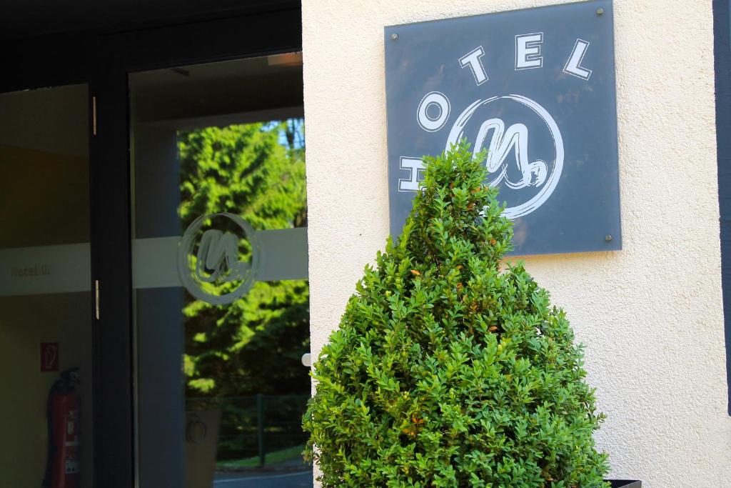 a christmas tree in front of a building with a sign at Hotel U. + Apartments in Mülheim an der Ruhr