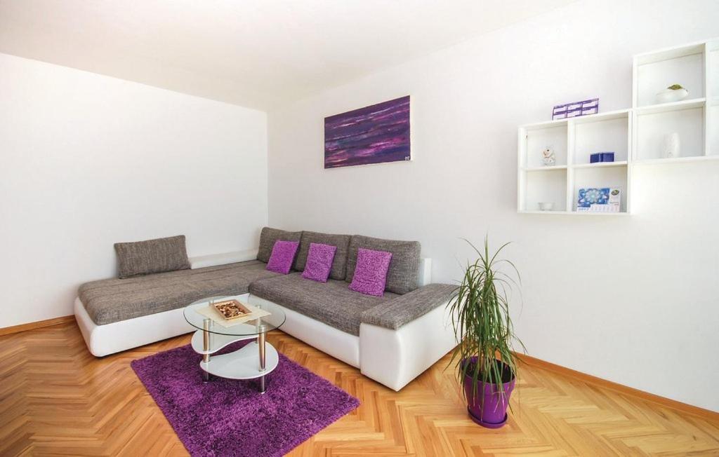 a living room with a couch and a purple rug at Apartment Skyscraper Maro in Rijeka