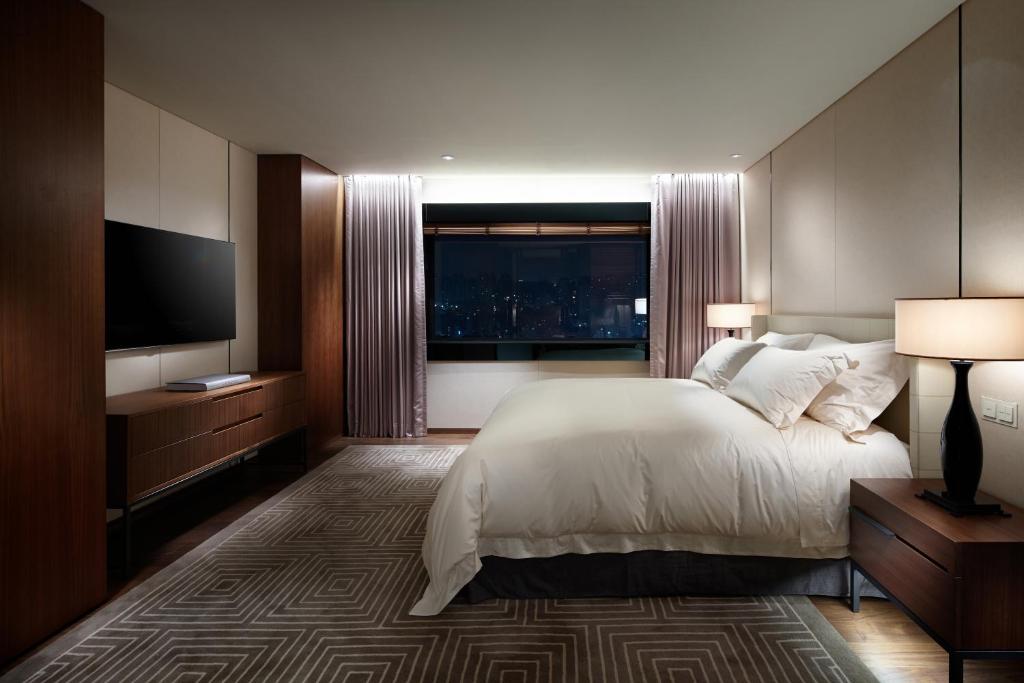 a bedroom with a large bed and a large window at The Shilla Seoul in Seoul