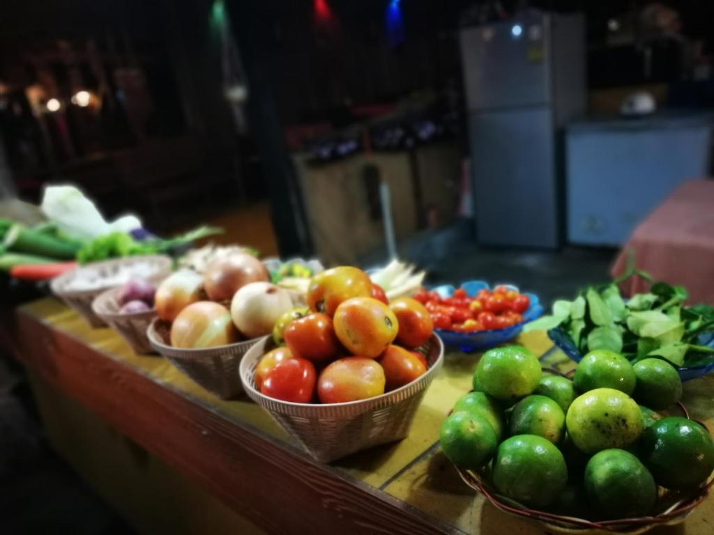 a table with bowls of fruits and vegetables on it at PP Red Tuna Hut in Phi Phi Don