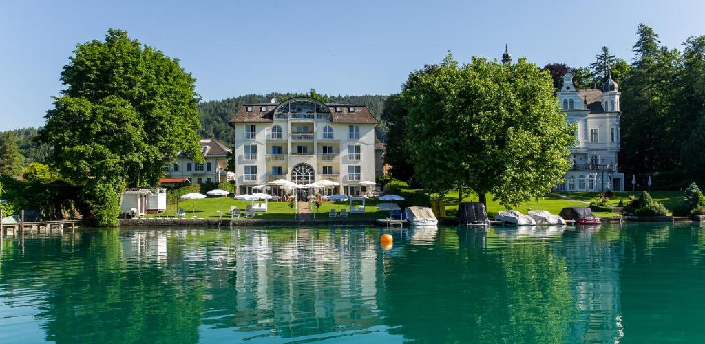 una grande casa seduta sopra un corpo d'acqua di Villa Christina a Pörtschach am Wörthersee