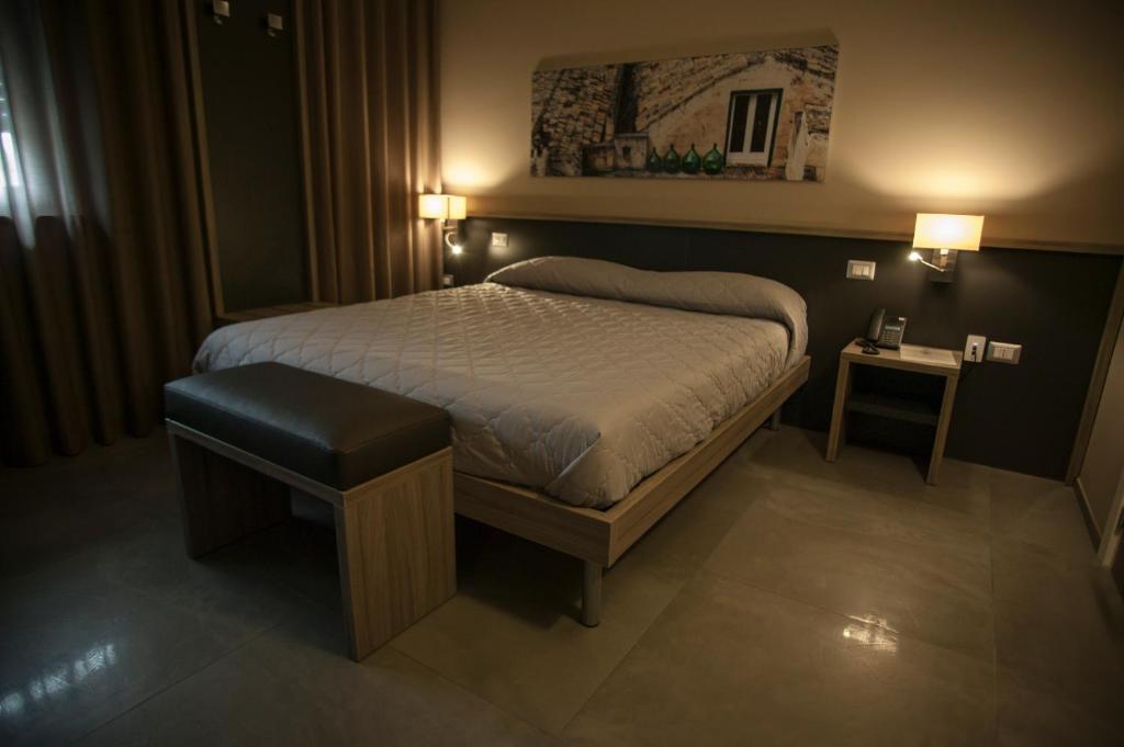 una camera con letto, sgabello e luci di La Sosta Motel Tavola Calda a Matera