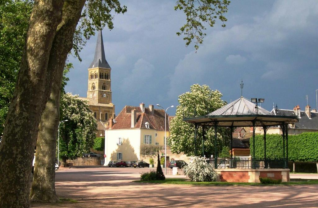 a building with a clock tower and a church at Chambres d'Hôte Le Clos de L'Argolay in Charolles