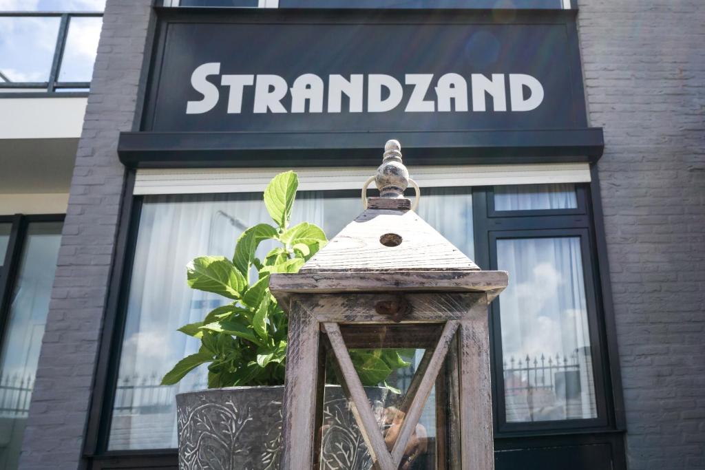 una tienda con un cartel en la parte delantera de un edificio en Strandzand, en Noordwijk aan Zee