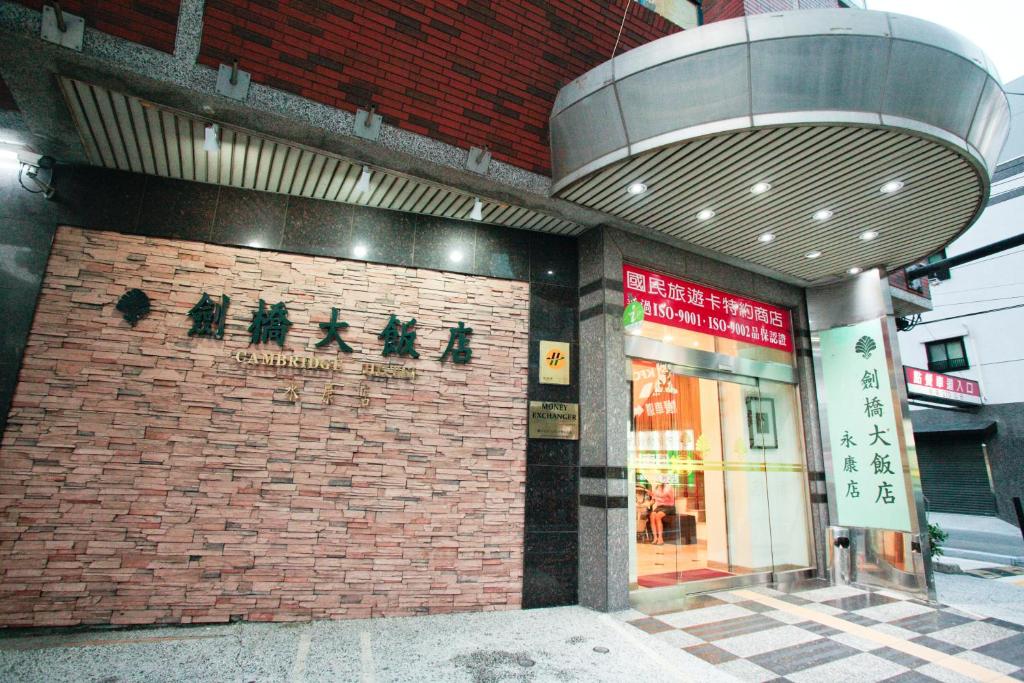 een bakstenen gebouw met een bord aan de zijkant bij Cambridge Hotel - Yung Kang in Yongkang