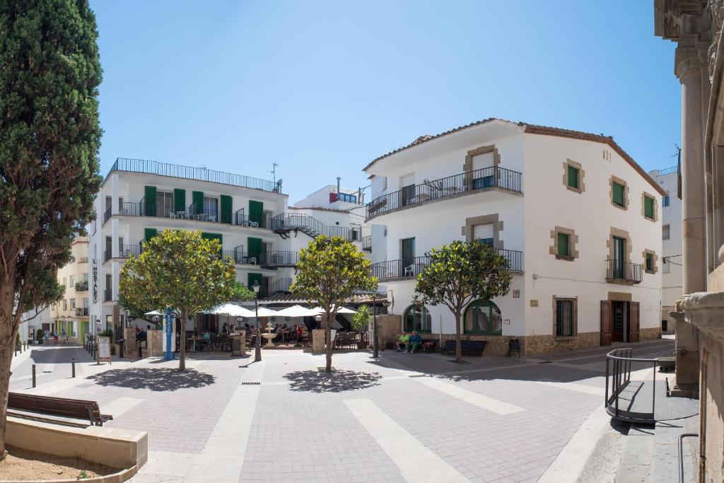 a street in a town with buildings and trees at L´Hostalet in Tossa de Mar