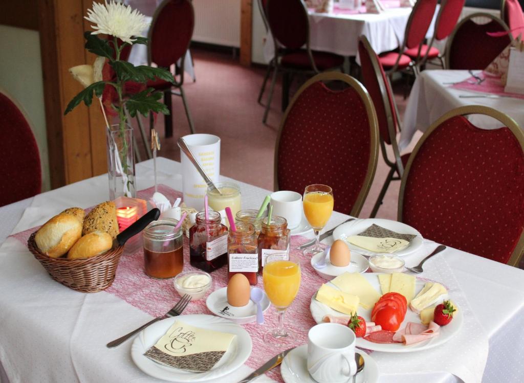 a table with breakfast foods and drinks on it at Pension &amp; Gasthaus Kattenstieg in Kattenstiegs-Mühle