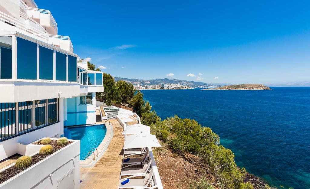 カラ・ヴィニャスにあるGlobales Apartamentos Cala Viñas ONLY ADULTS 16の建物のバルコニーから海の景色を望めます。