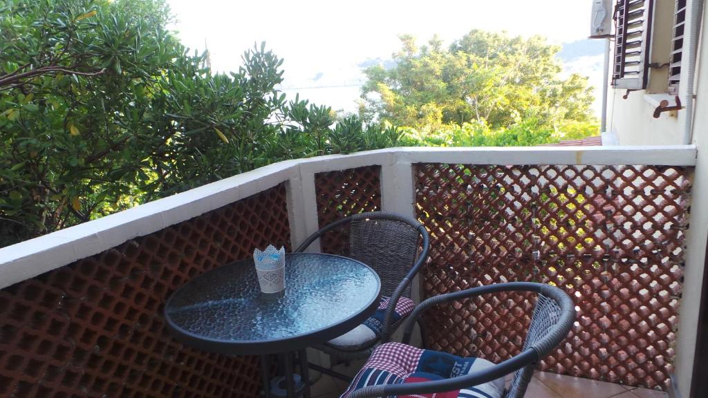 a table and two chairs sitting on a balcony at Apartments Andrea in Baška