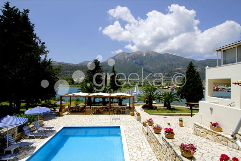 a swimming pool in front of a house at Geni Garden Apartments in Yenion