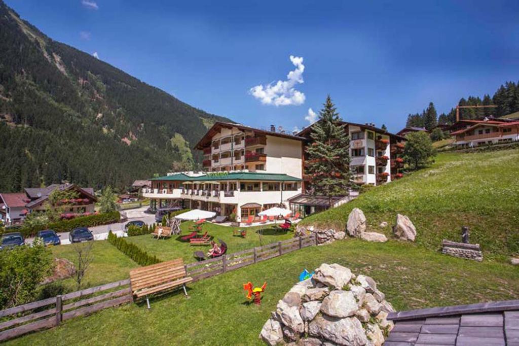 ein Gebäude auf einem Hügel mit einem Park davor in der Unterkunft Alpenwellnesshotel Gasteigerhof in Neustift im Stubaital