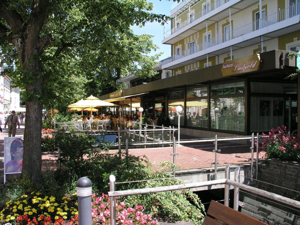 un edificio con una cafetería y flores delante de él en Kurhotel Luitpold en Bad Wörishofen