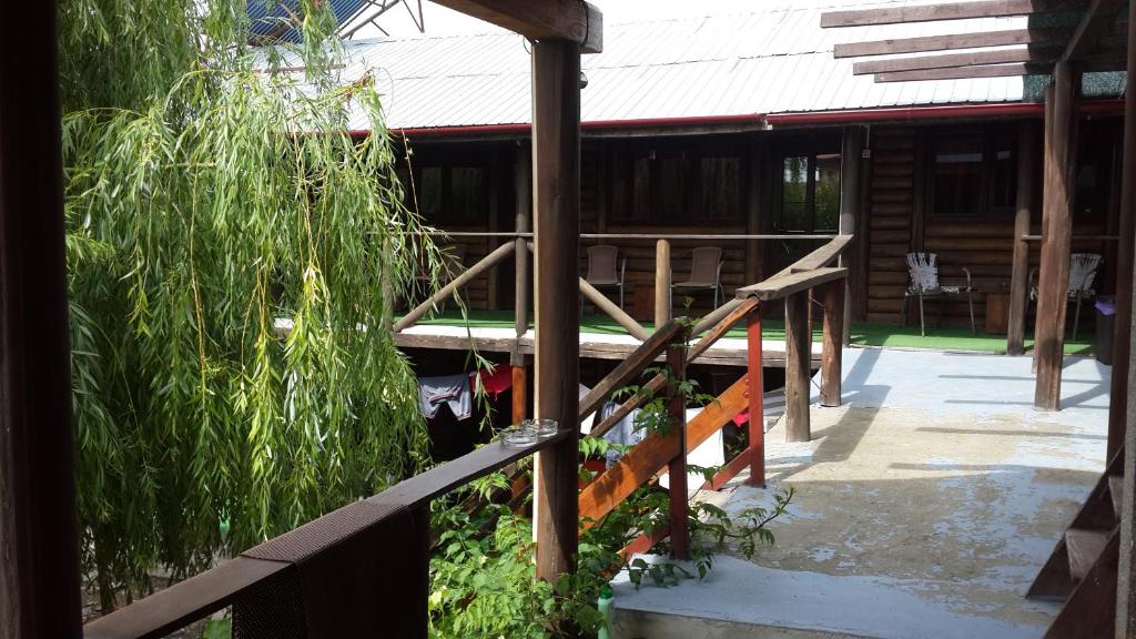 une terrasse couverte d'une maison avec une balustrade en bois dans l'établissement Casa Dexter, à Vama Veche