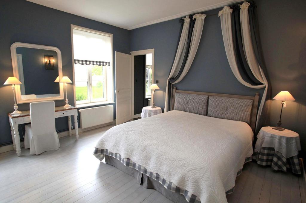 a bedroom with a bed and a mirror and a window at Côte d&#39;Opale - La Ferme des Saules in Millam