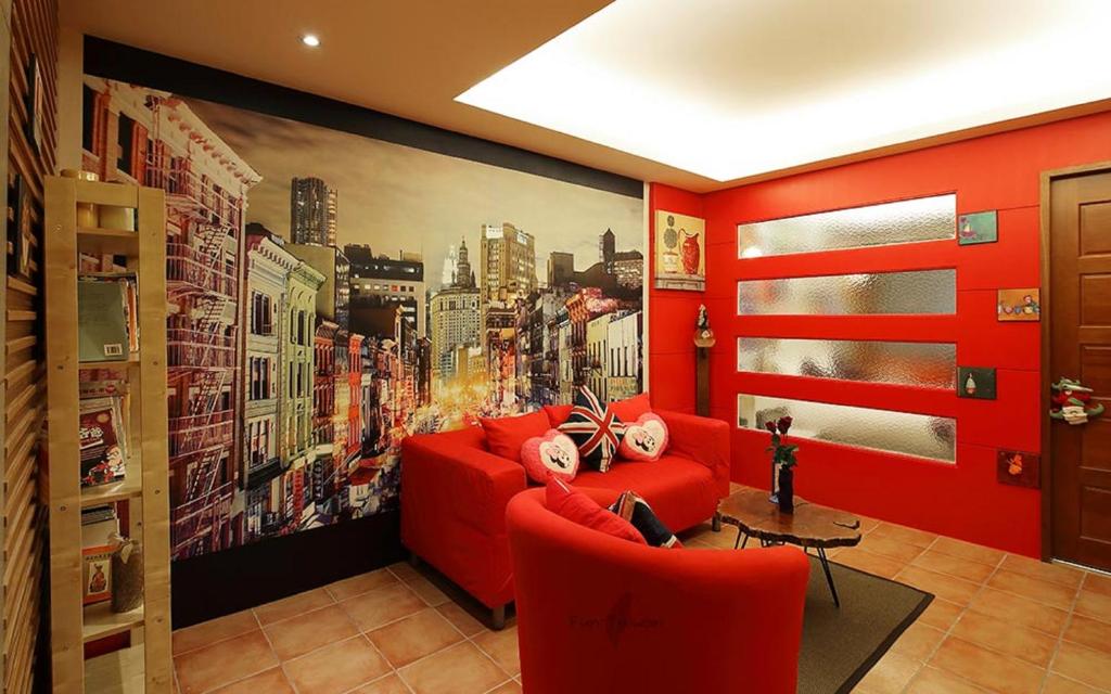 a living room with red furniture and a large painting at Park 61 in Luodong