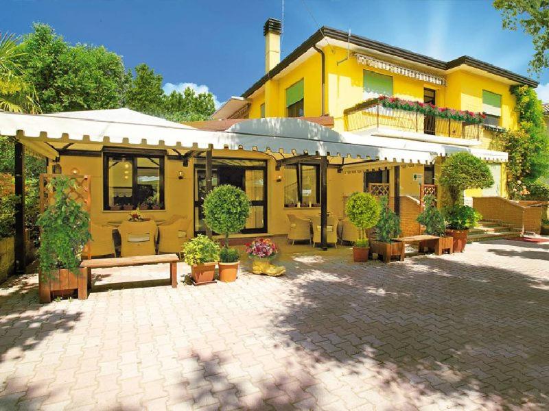 a yellow house with a bench in front of it at Locanda da Scarpa in Cavallino-Treporti