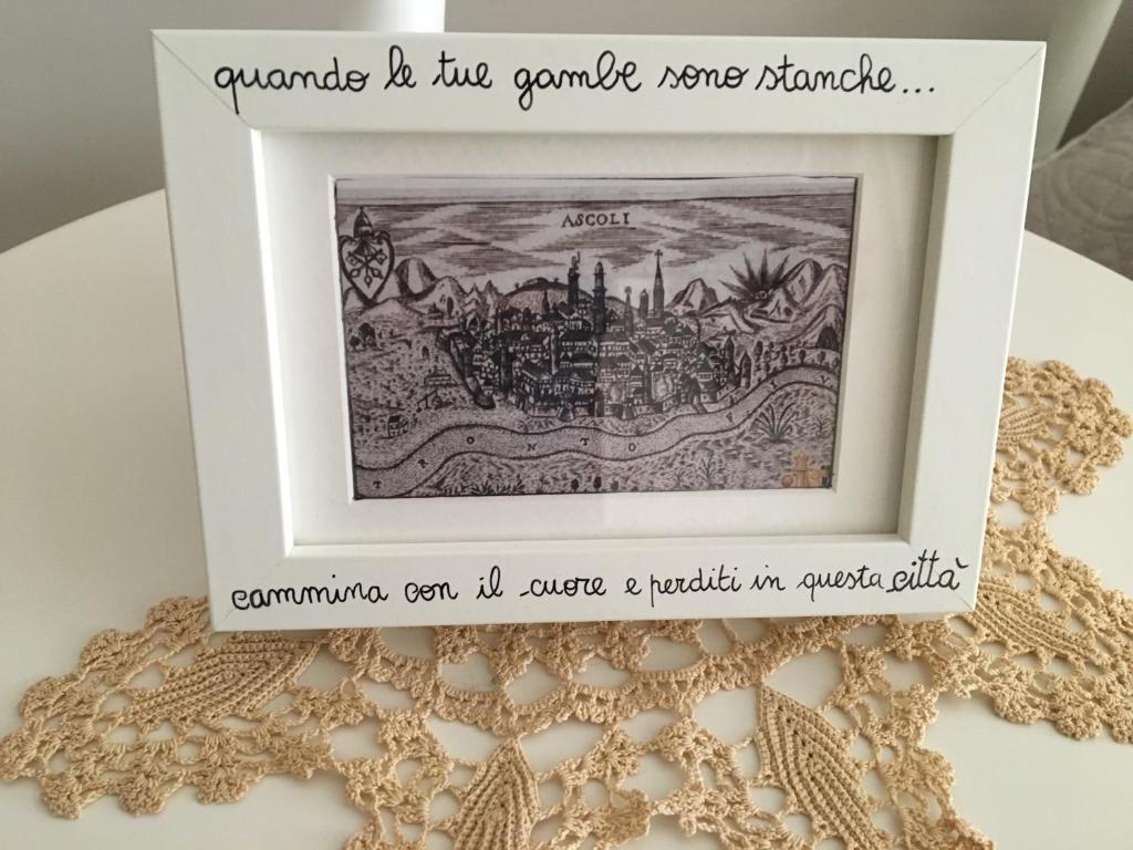 un quadro incorniciato di un dipinto di una città di B&B Piazza Viola ad Ascoli Piceno