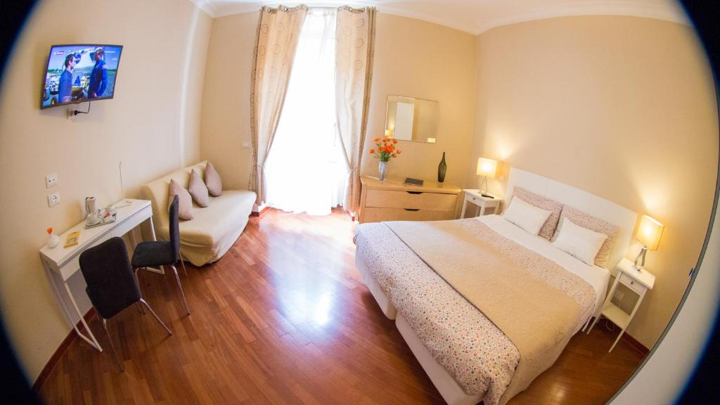 a bedroom with a bed and a desk and a window at Hotel Martino Ai Monti in Rome