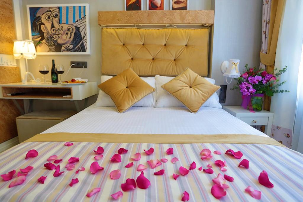 イスタンブールにあるジャスト イン ホテルのピンクのバラの花びらが飾られたベッド