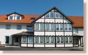 a large white building with a red roof at Hotel Garni Burgstemmer Hof in Burgstemmen