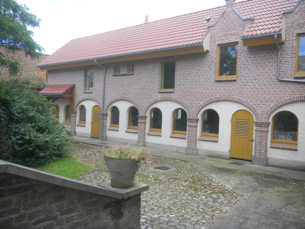 a large brick building with yellow doors and a courtyard at Verreveld in Londerzeel