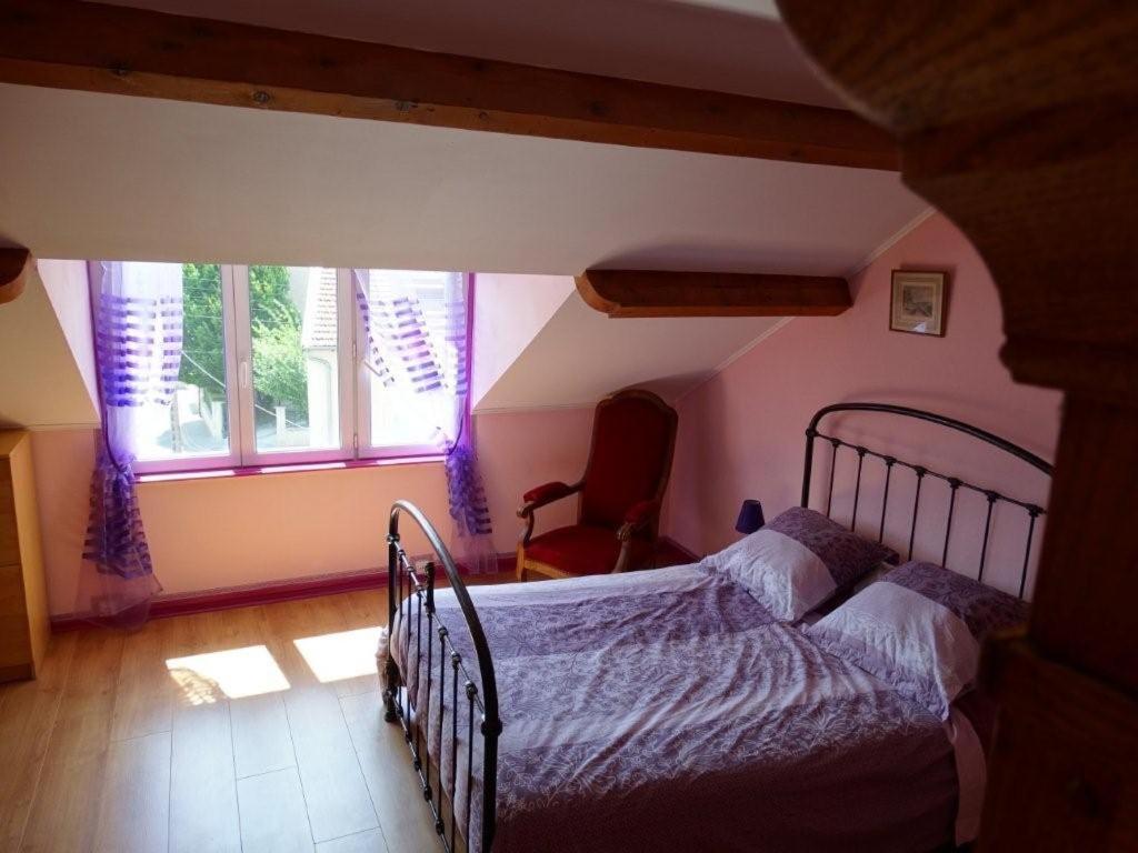 a bedroom with a bed and a large window at Chez Ghislaine in Verdun