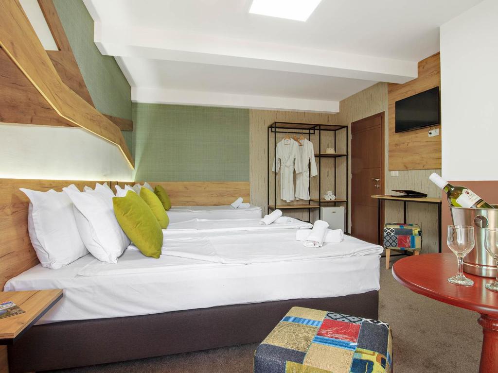 Cette chambre comprend un grand lit blanc et une table. dans l'établissement Villa Caposki, à Ohrid
