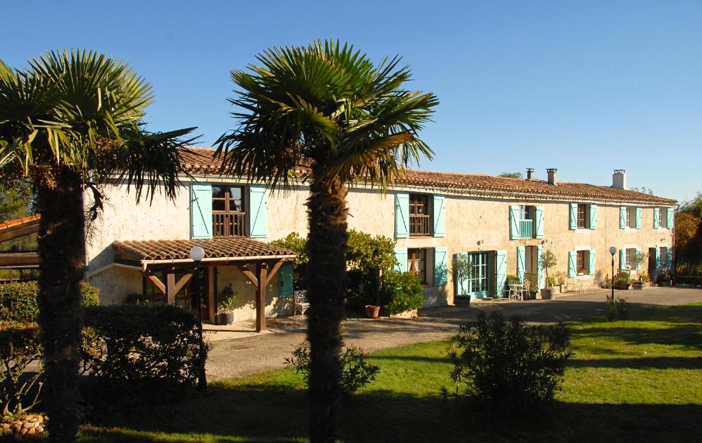 ein Haus mit zwei Palmen davor in der Unterkunft Domaine Saladry in Villepinte