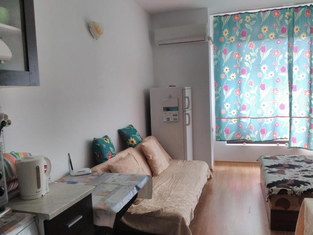 a living room with a couch and a refrigerator at Sea Apartment in Burgas