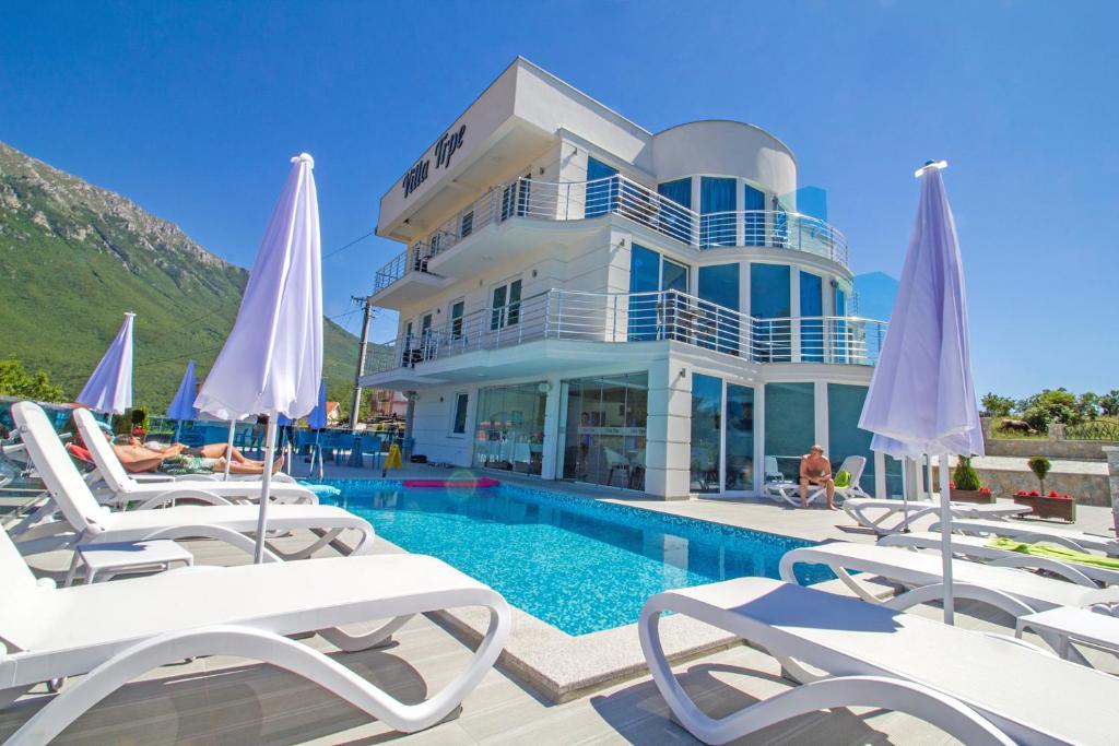 une villa avec une piscine et des chaises longues dans l'établissement Villa Trpe, à Ohrid