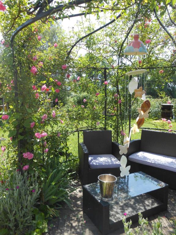 a garden with two couches and a table and flowers at Chambre D'hôtes Myrtille in Usson-en-Forez