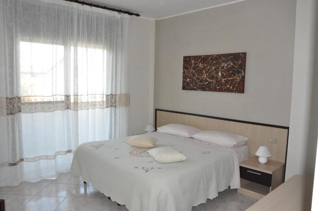 a white bedroom with a bed with two pillows at Bed & Breakfast Oasi in Pescara