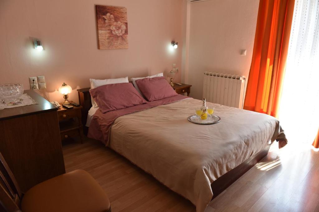 Un dormitorio con una cama y una bandeja con velas. en 40 Platania Hotel, en Loutra Edipsou