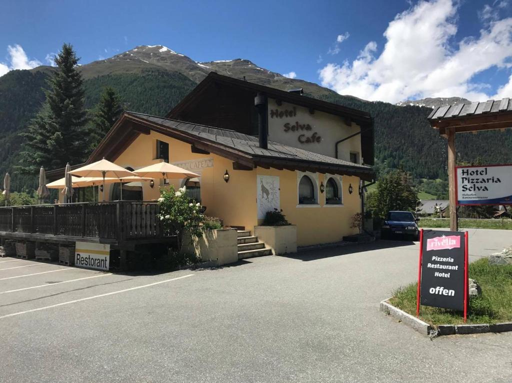 un edificio con una señal delante de él en Hotel Pizzeria Selva, en Zernez