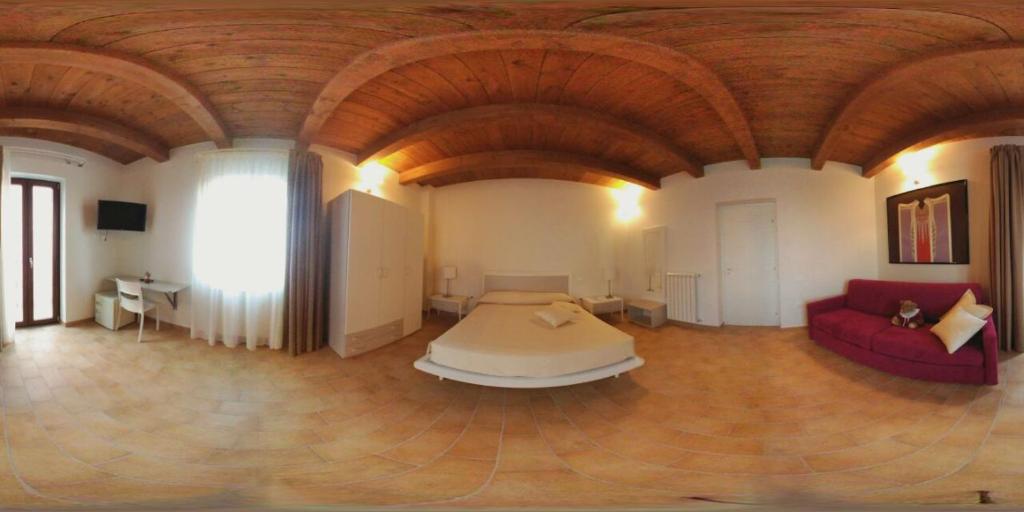 Großes Zimmer mit einem Bett und einem Sofa in der Unterkunft Sotto il Castello in Corigliano Calabro