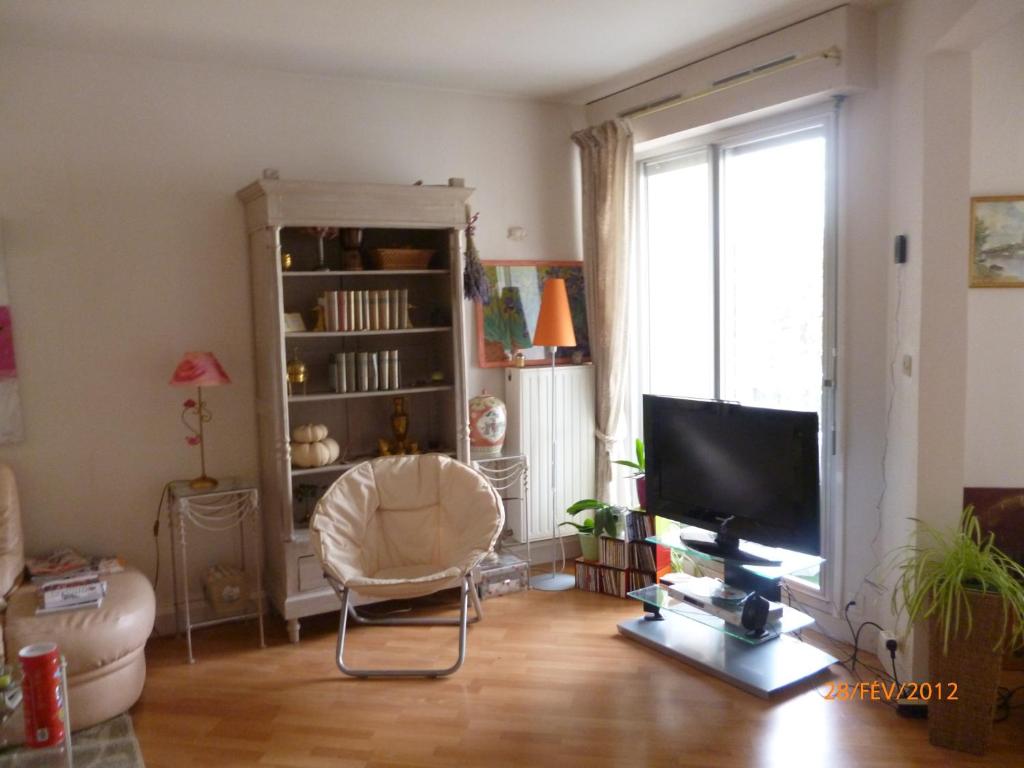 a living room with a chair and a television at L&#39;appartement du Haut Plessis in Blois