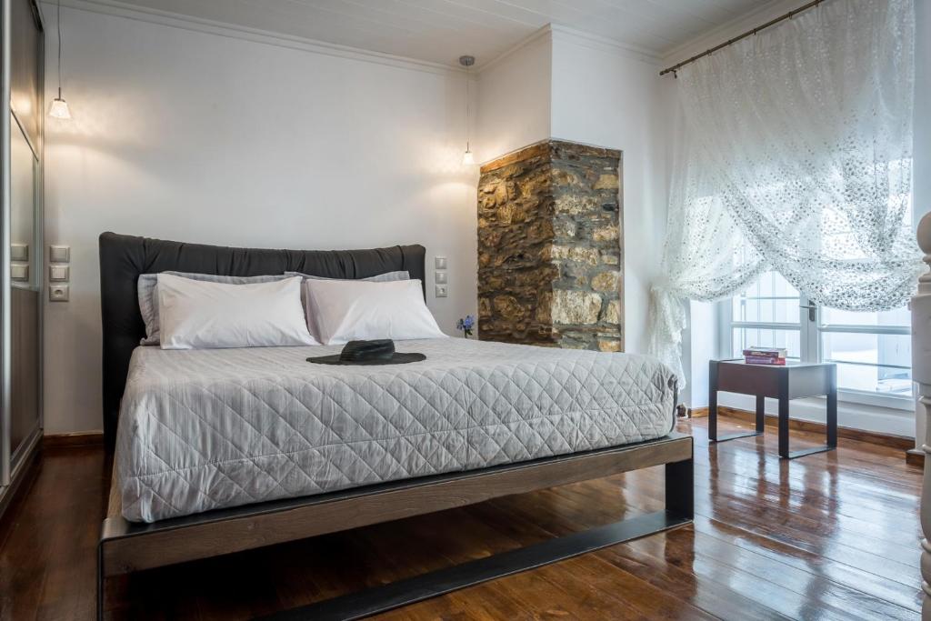 sypialnia z dużym łóżkiem i oknem w obiekcie EVAGELIA'S APPARTMENT w mieście Skopelos