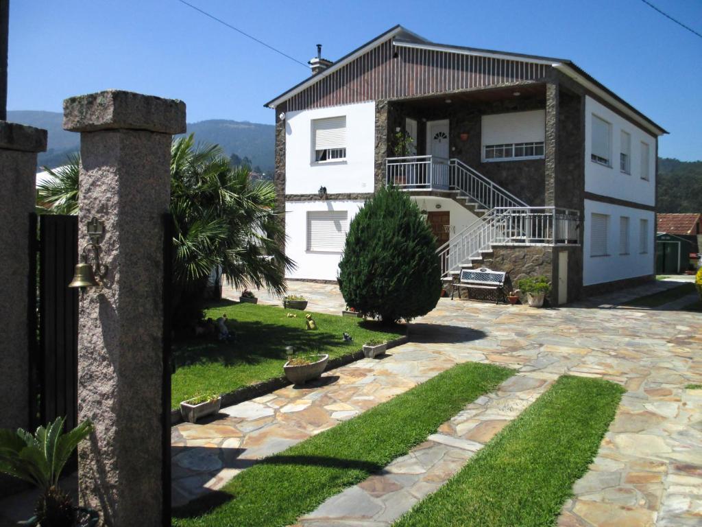 a large white house with a stone patio at Casa Sabarís in Baiona