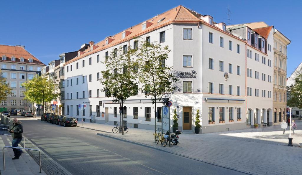 ミュンヘンにあるホテル ブラウアー ボックの市道の白い大きな建物