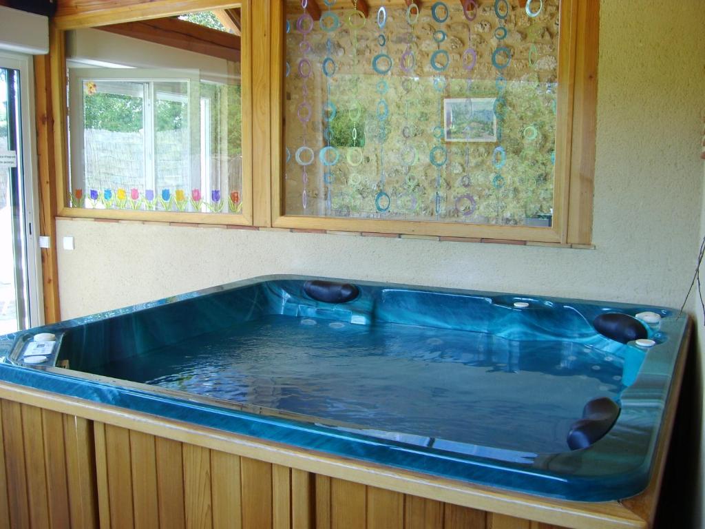 une grande baignoire bleue dans une cuisine avec une fenêtre dans l'établissement Au lézard doré, à Lamonzie-Montastruc