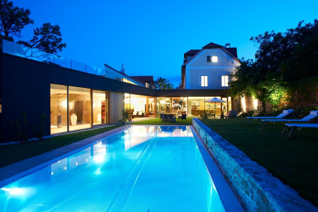 basen na podwórku domu w nocy w obiekcie Hotel Landhaus Moserhof w mieście Gumpoldskirchen